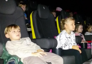 Widok na dzieci siedzące na widowni kinowej.